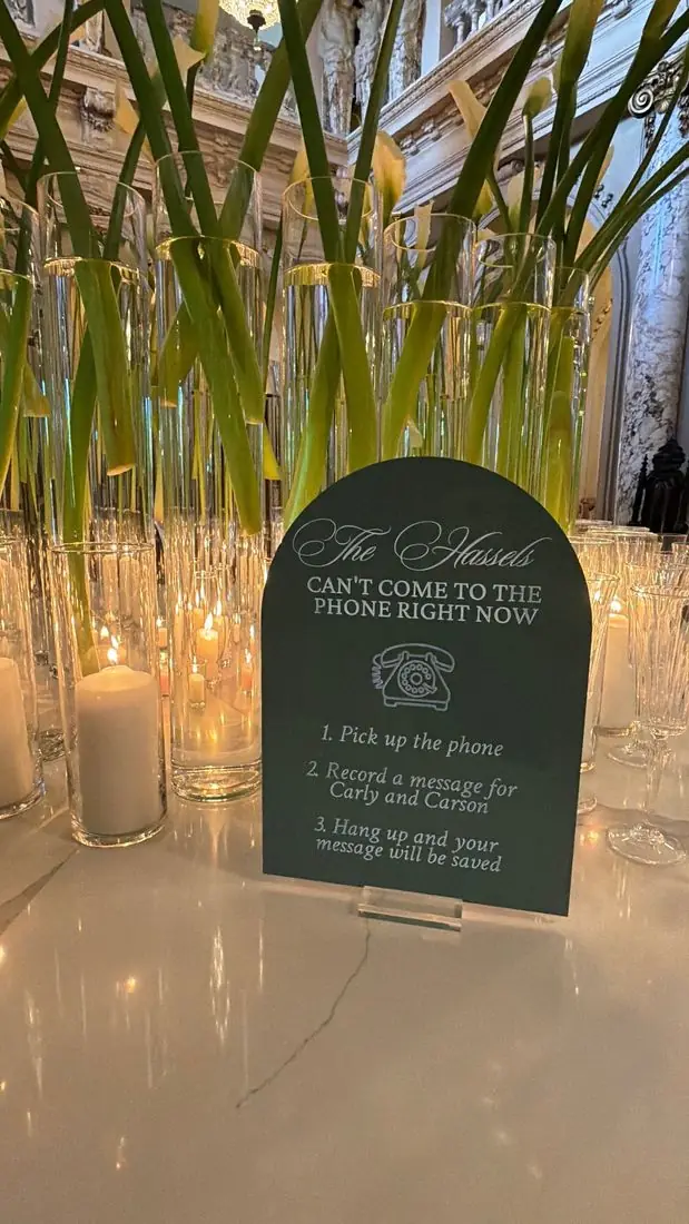 Arched sage green acrylic sign inviting guests to record a voicemail message for Carly and Carson